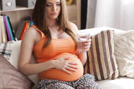 Mulher grávida tomando água