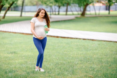 Mulher grávida caminhando no parque