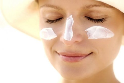 Mulher hidratando a sua pele com um creme