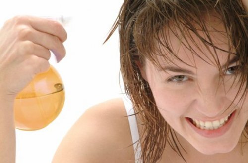 Mulher usando produto para manter o cabelo ruivo