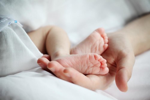 Mãe segurando os pés do seu bebê