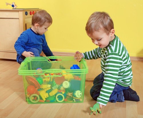 Crianças guardando brinquedos para bebês