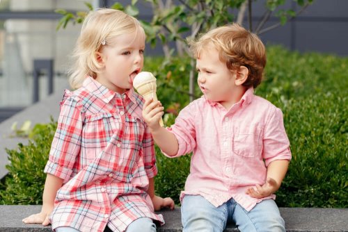 Criança dando sorvete para a outra