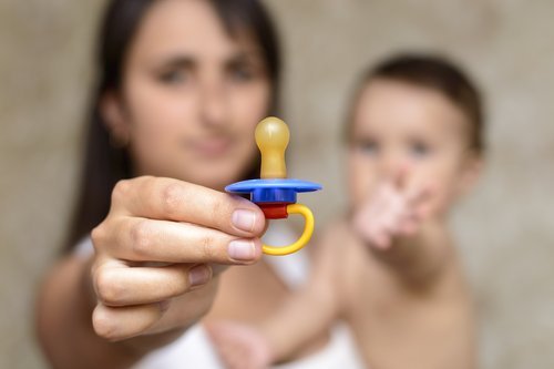 Mãe tirando a chupeta do bebê
