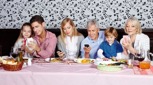 Refeição em família que está usando o celular