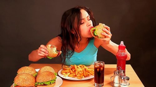 Mulher comendo fast food