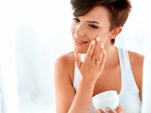 Mulher passando creme no rosto