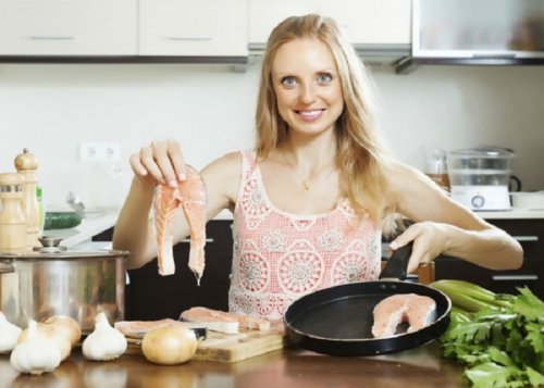 Mulher fazendo peixe em casa