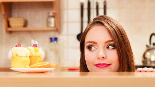 Mulher resistindo a comer doce