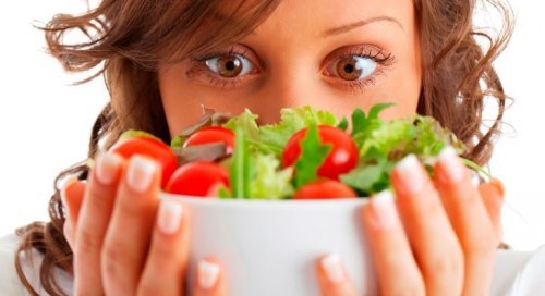 Mulher segurando salada grega