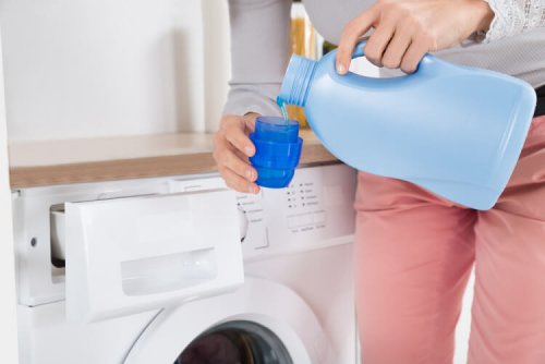 Mulher colocando amaciante na lavadora