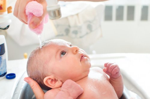 Mãe dando banho ao seu filho nos primeiros meses do bebê