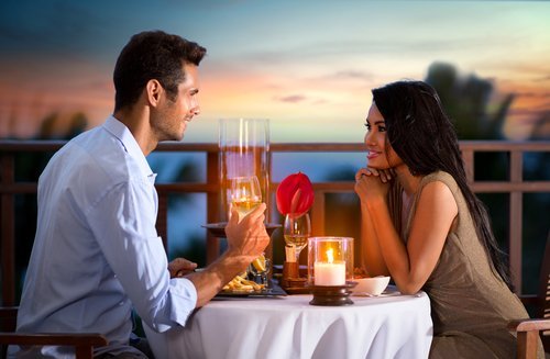 Casal relaxando no jantar com velas e óleos aromáticos