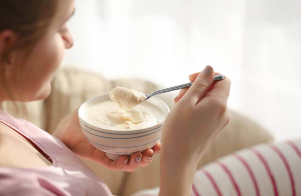 mulher comendo iogurte caseiro