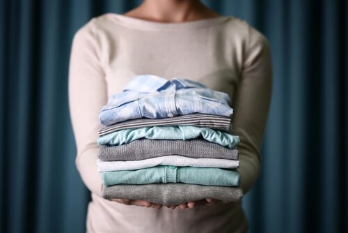 Mulher segurando roupas renovadas