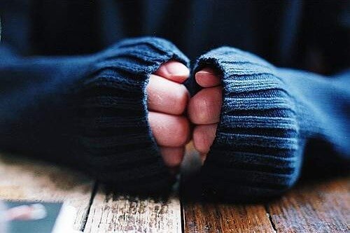 Pessoa escondendo o pé de atleta nas mãos