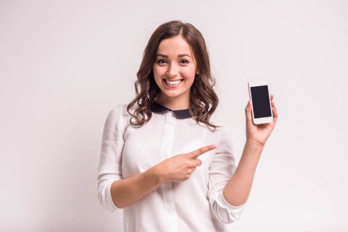 Mulher mostrando o celular pelo qual pode prognosticar os dias férteis