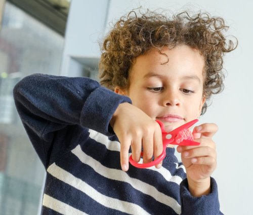 Criança usando tesoura infantil
