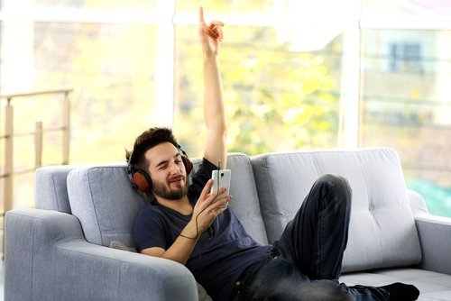 Homem usando fones de ouvido para ouvir música do celular