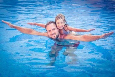 Pai ensinando sua filha a nadar