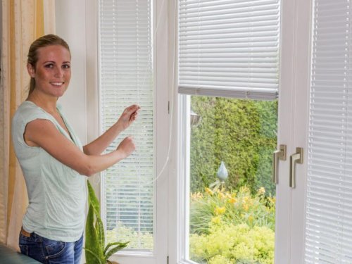 Mulher abrindo persianas