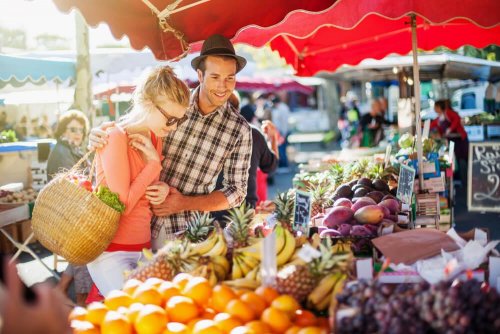 Casal escolhendo frutas para se cuidar sem renunciar à vida social