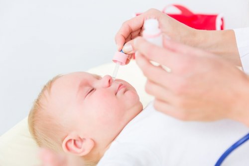 Mãe usando um dos métodos para eliminar o muco nas crianças
