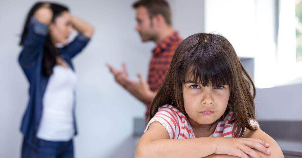 Menina triste com os pais brigando
