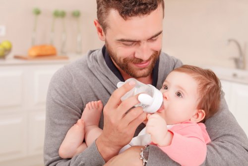 Pai dando mamadeira ao filho
