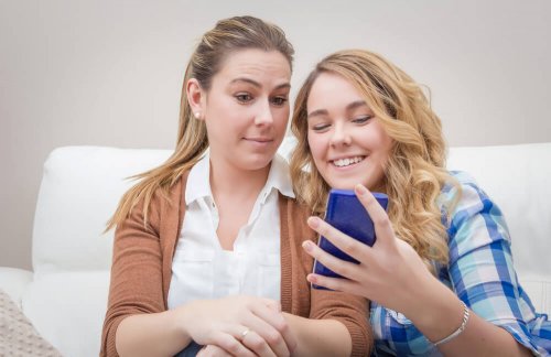 Mãe verificando o celular da filha para ver as redes sociais