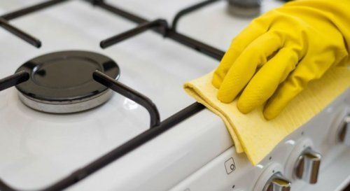 Mulher limpando o fogão de maneira natural