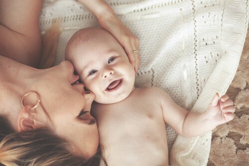 Mãe dando massagens para bebês e carinho ao filho