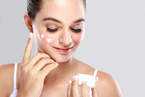 Mulher passando um creme regenerador