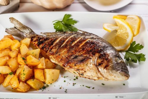 Delicioso robalo assado com batatas e cebolas