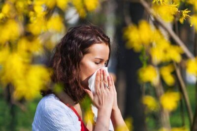 Moça espirrando pela alergia ao pólen