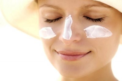 Mulher usando protetor solar contra o melasma
