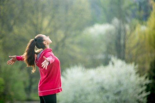 Mulher fazendo exercícios de respiração com braços abertos