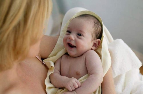Mãe lavando cabelo do bebê com produtos adequados