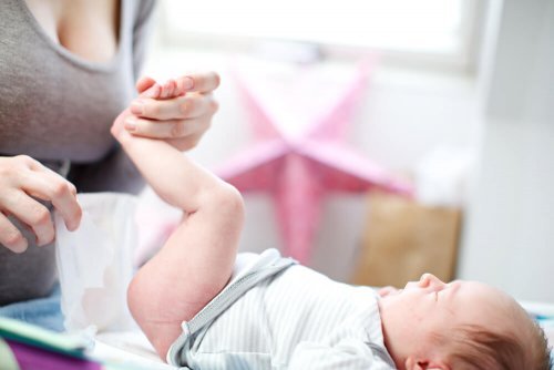 Mãe checando dermatite de fralda no bebê