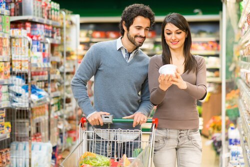 Casal fazendo compras e olhando os rótulos nutricionais