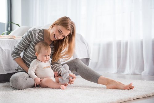Mãe ensinando bebê a se sentar