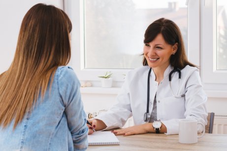 Médico explicando futura mãe sobre pré-eclâmpsia