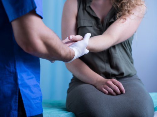 Médico examinando feridas nas mãos e dedos
