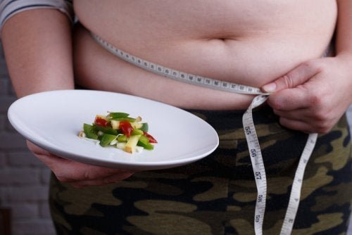 Homem obeso com uma fita métrica e um prato