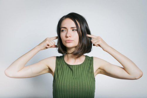 Mulher protegendo os aouvidos do barulho