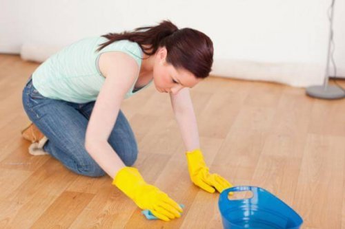 Mulher tentando limpar resíduos pegajosos do piso