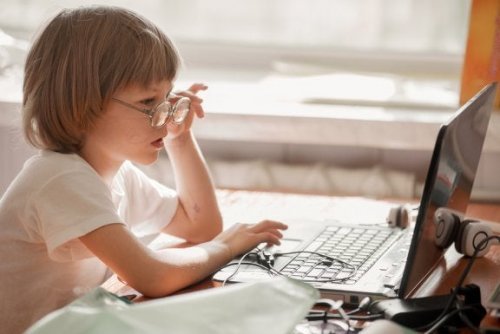 Menino com óculos no computador