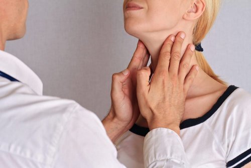 Pescoço da mulher sendo palpado por um médico para controle da tireoide.
