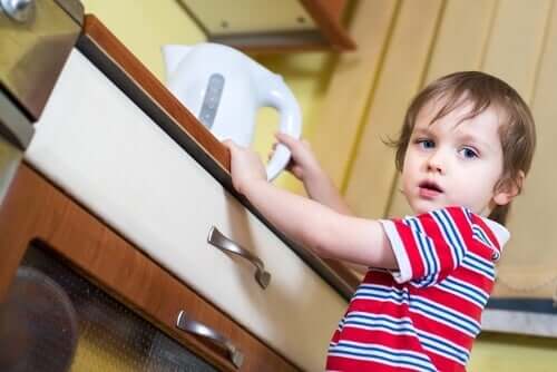 Garoto pegando recipiente com água quente