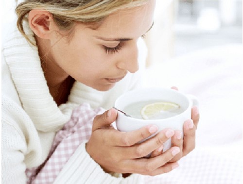 Mulher gripada tomando chá